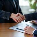 People shaking hands across a table, representing consultation